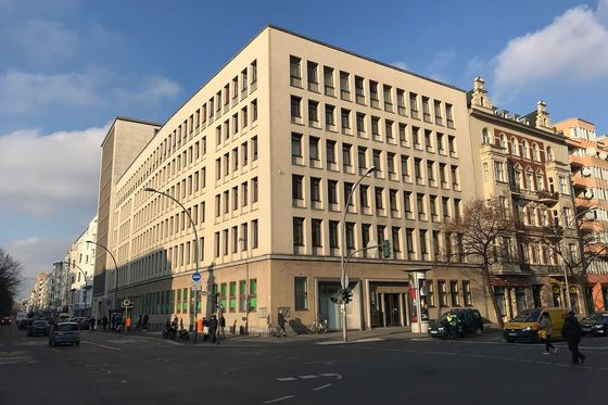 Großes helles Bürogebäude des Finanzamts Schöneberg an einer Straßenkreuzung in Berlin