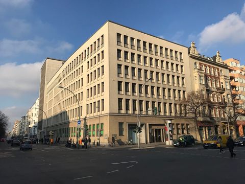 Großes helles Bürogebäude des Finanzamts Schöneberg an einer Straßenkreuzung in Berlin
