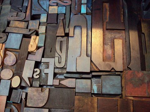 Durcheinanderliegende alte Holzlettern für den Buchdruck in verschiedenen Größen und Farben